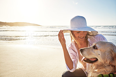 Buy stock photo Shot of a mature woman taking her dog for a walk on the beach