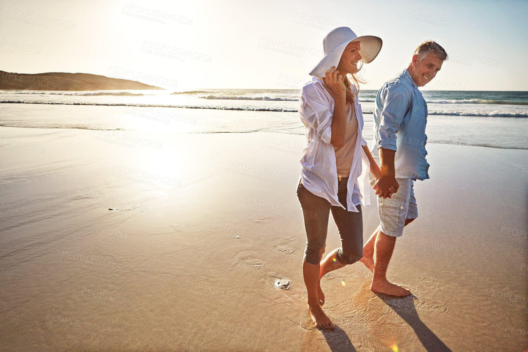 Buy stock photo Happy couple, walk and holding hands on beach for vacation on island or coast for getaway, travel and holiday. Woman, man and relationship for love or marriage anniversary by ocean at sunrise in Bali