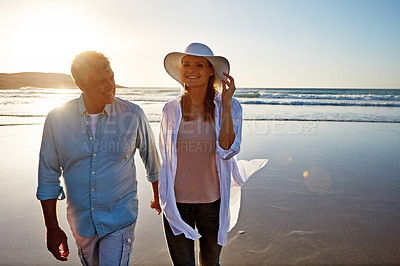 Buy stock photo Mature, happy couple and holding hands with beach sunset for love, embrace or bonding together in nature. Man, woman or lovers enjoying stroll with smile for outdoor holiday or summer by ocean coast