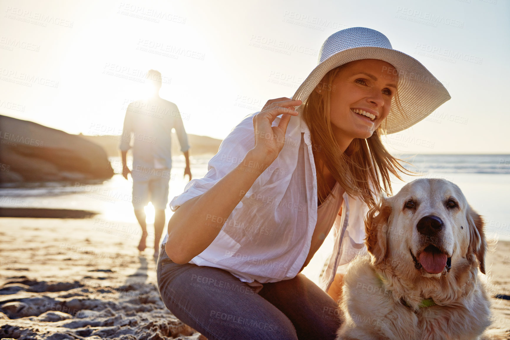 Buy stock photo Shot of a mature woman taking her dog for a walk on the beach