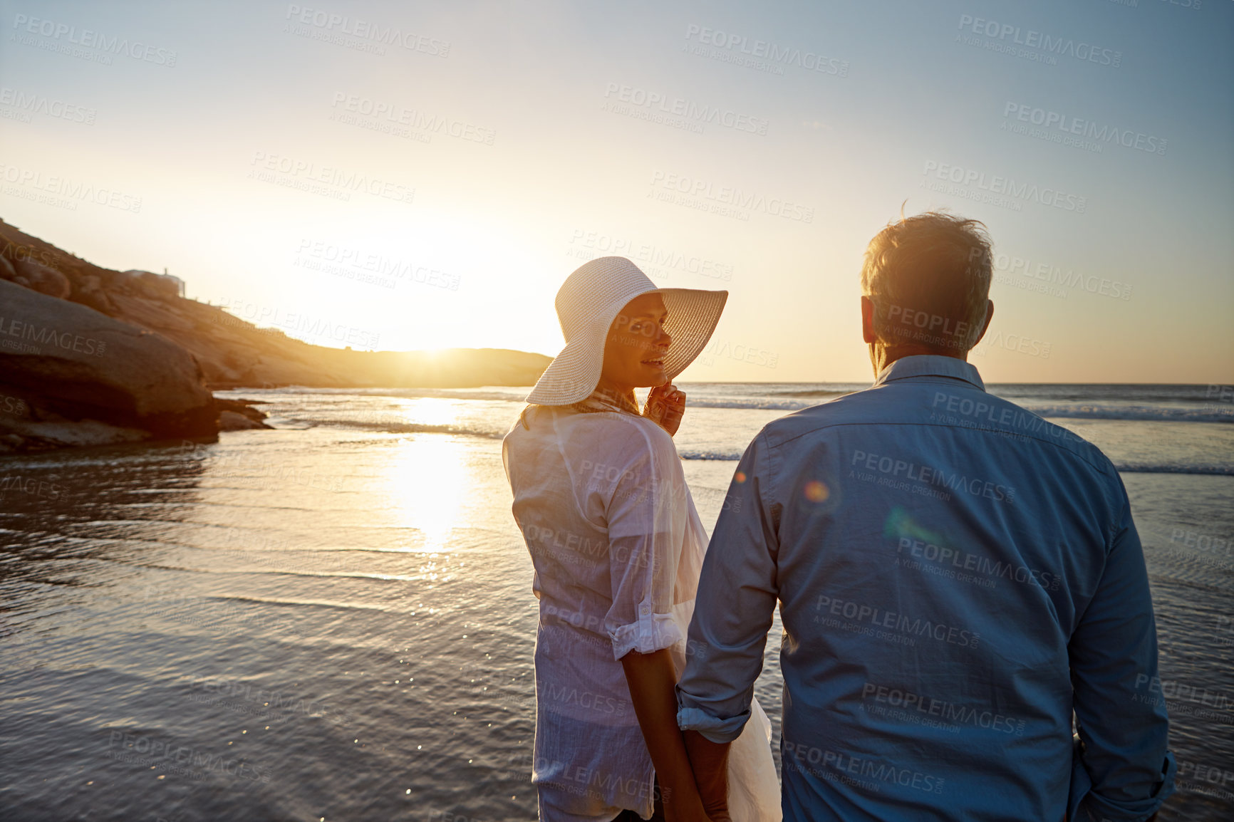 Buy stock photo Mature, happy couple and walking with love on beach in sunset for support or bonding in nature. Back view of man, woman or lovers enjoying romance, outdoor holiday or summer by water or ocean coast