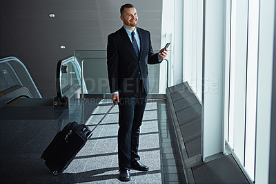 Buy stock photo Smile, thinking or businessman in airport with phone, luggage or suitcase waiting to travel. Social media, happy entrepreneur or corporate worker texting to chat on mobile app on international flight