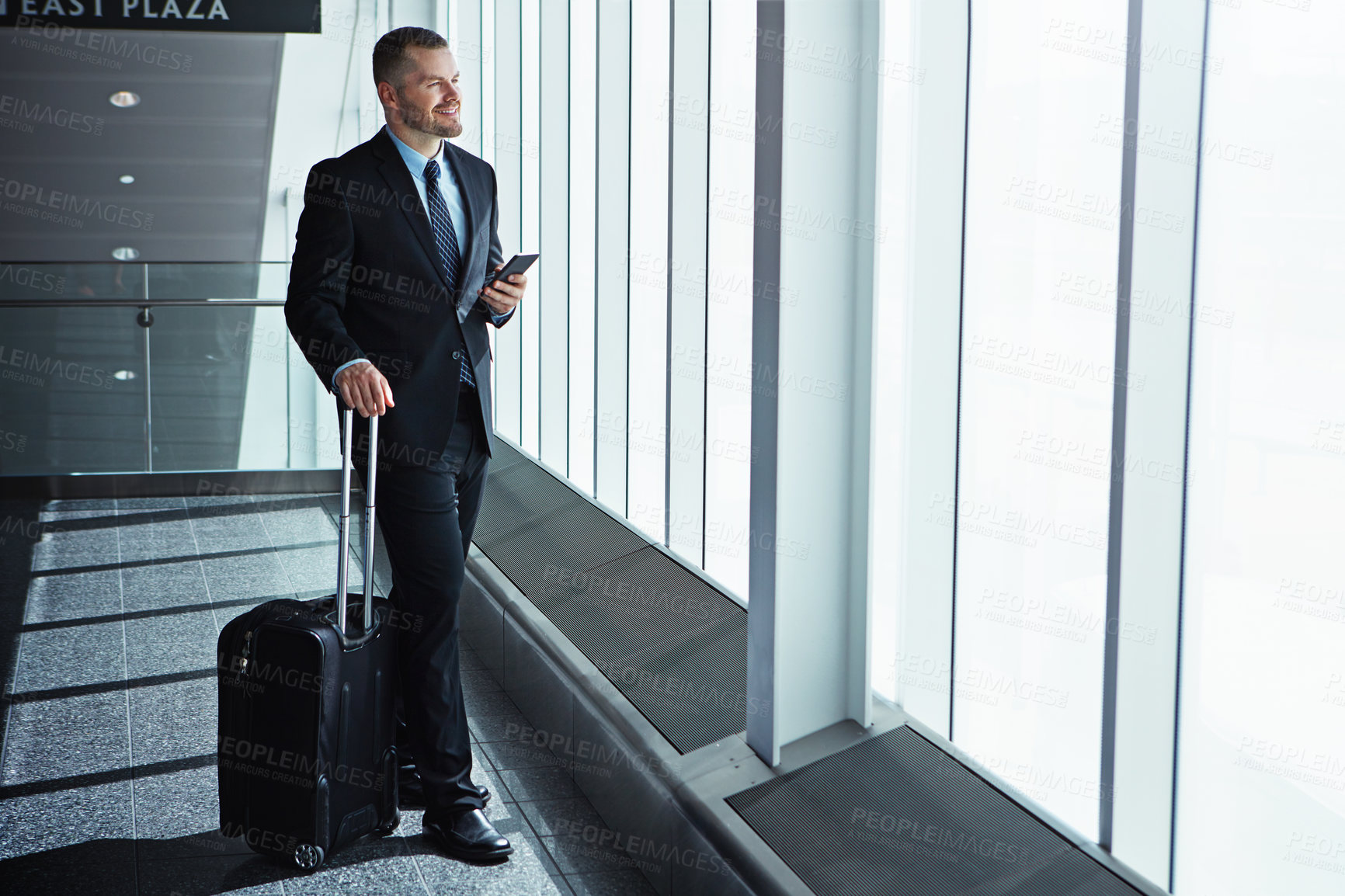 Buy stock photo Business man, phone and airport window with suitcase for smile, thinking and idea for international travel. Entrepreneur, luggage and smartphone with flight schedule for global immigration in London