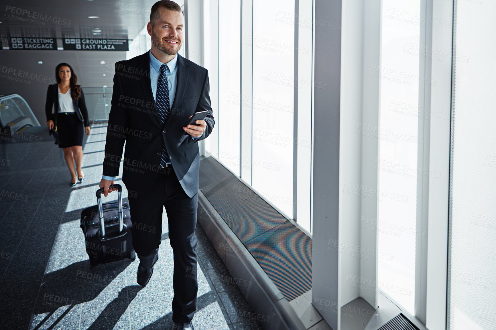 Buy stock photo Business man, woman and phone in airport hallway with smile, thinking or suitcase for international travel. Entrepreneur, luggage and smartphone with flight schedule for global immigration in London