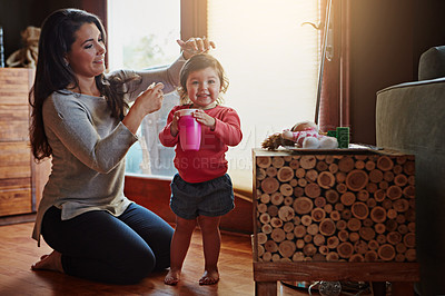 Buy stock photo Shot of a mother dressing her adorable little daughter at home