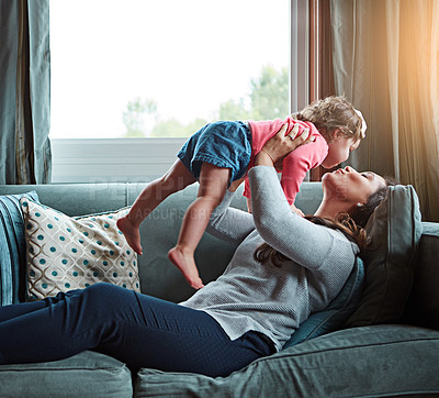 Buy stock photo Relax, happy and kiss with mother and baby on sofa for bonding, quality time and child development. Growth, support and trust with mom and daughter in family home for health, connection and care