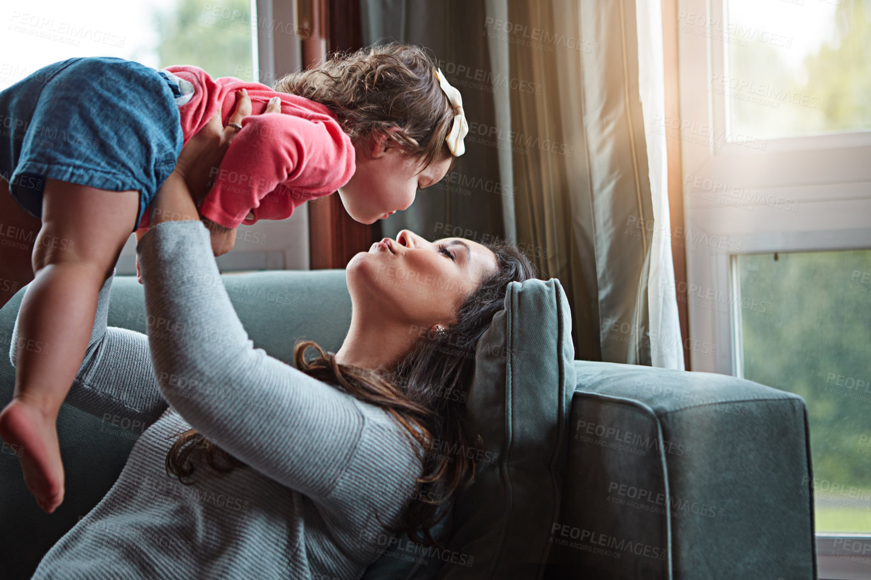 Buy stock photo Relax, happy and kiss with mother and baby on sofa for bonding, quality time and child development. Growth, support and trust with mom and daughter in family home for health, connection and care