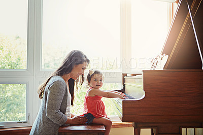 Buy stock photo Playing, music and mother and child with a piano, learning and happy together in a house. Love, smile and portrait of a playful baby with her fun mom teaching to play an instrument for happiness