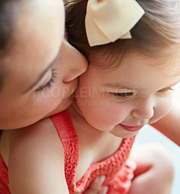 Buy stock photo Mother kissing her girl baby on her cheek while playing, bonding and spending time together. Happy, smile and girl infant child sitting with her mom in their modern family home with love with care.
