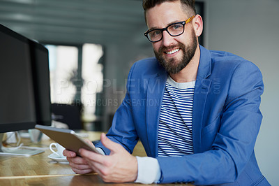 Buy stock photo Portrait of a young businessman working on a digital tablet in an office