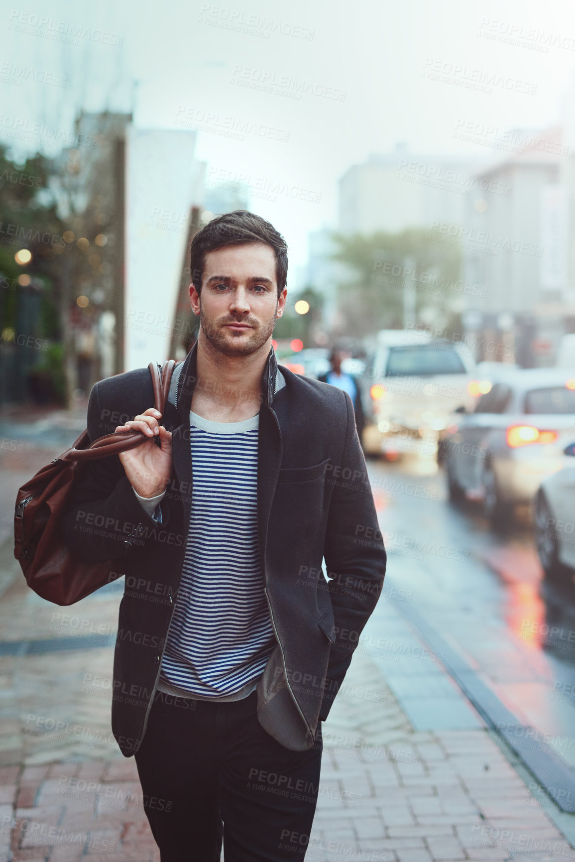 Buy stock photo Cropped portrait of a handsome young man walking through the city