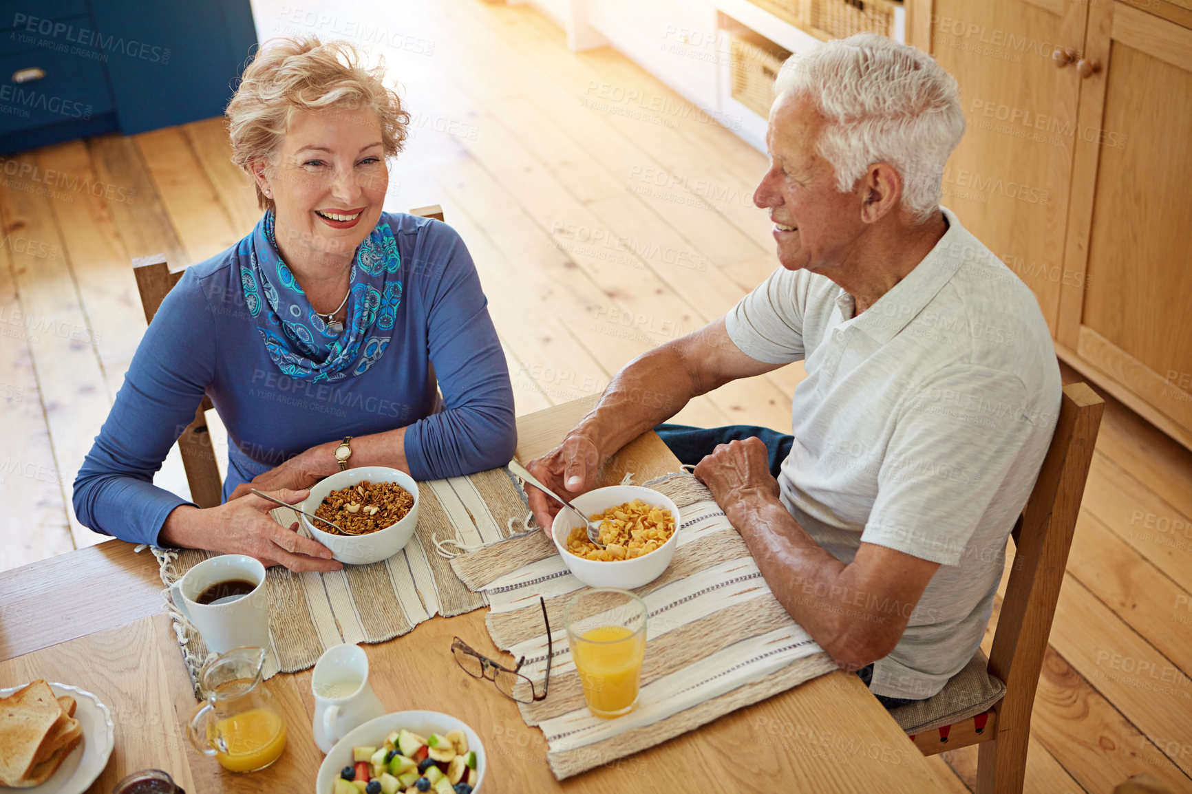 Buy stock photo Senior, couple and smile with eating at breakfast in dining room for nutrition, healthy meal and retirement. Elderly, people and happy in home with conversation, relax and morning routine from above