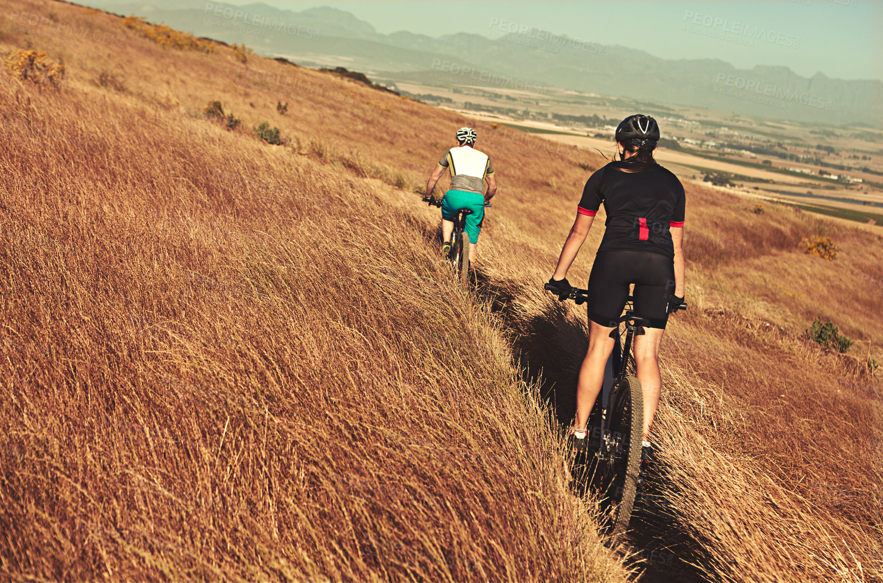 Buy stock photo Shot of two cyclists out cycling in the countryside