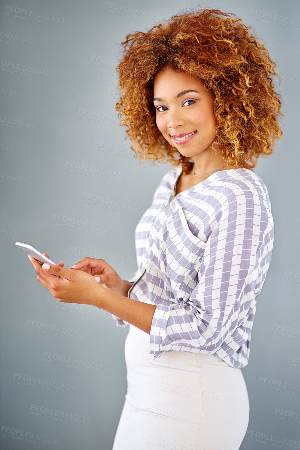 Buy stock photo Business woman, portrait and browsing with phone in studio for online app or communication on a gray background. Young, female person or employee with smile on mobile smartphone for chat in Jamaica