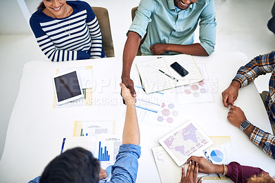 Buy stock photo High angle shot of designers shaking hands during a meeting in an office