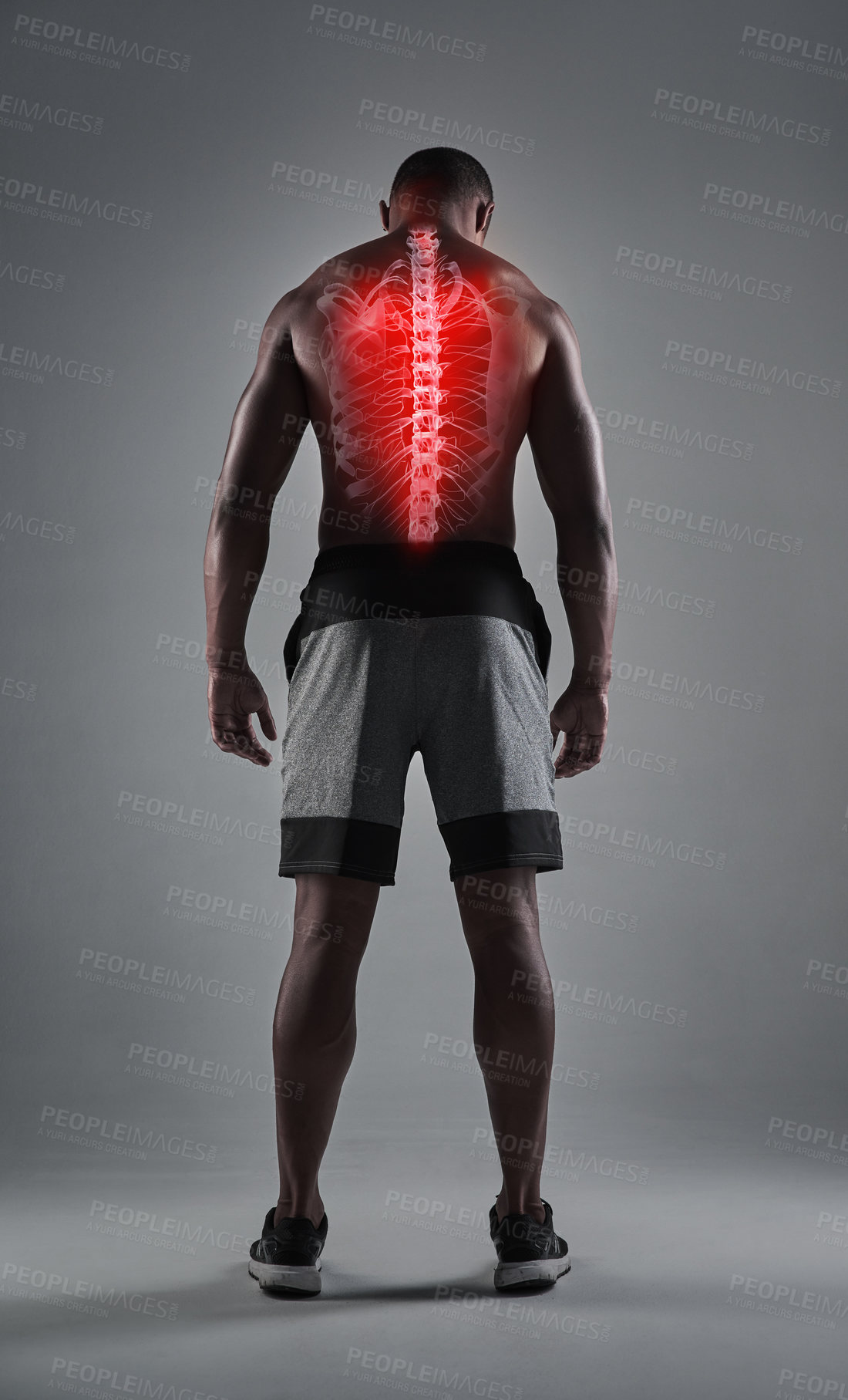 Buy stock photo Rearview shot of an athletic young man with his back injury highlighted