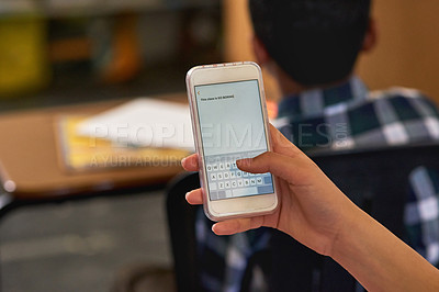Buy stock photo Shot of an unidentifiable schoolgirl using her smartphone in class