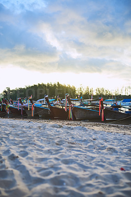 Buy stock photo Shot of traditional wooden boats resting on a beach in Thailand