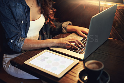 Buy stock photo Shot of an unidentifiable young woman using her laptop in a coffee shop