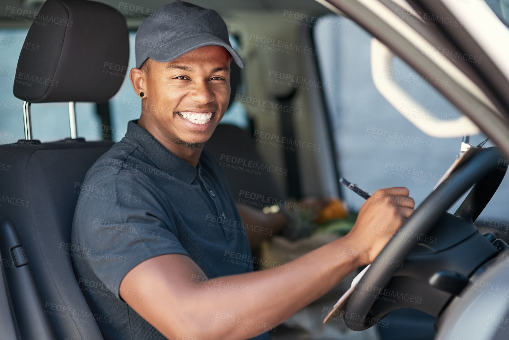 Buy stock photo Portrait of a courier writing on a clipboard while sitting in his van