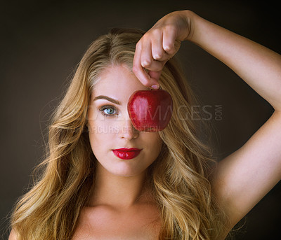 Buy stock photo Portrait, red apple and woman with beauty, makeup and cosmetics on dark studio background. Face, person and girl with fruit, glamour and lipstick with color, shine and aesthetic with glow and luxury