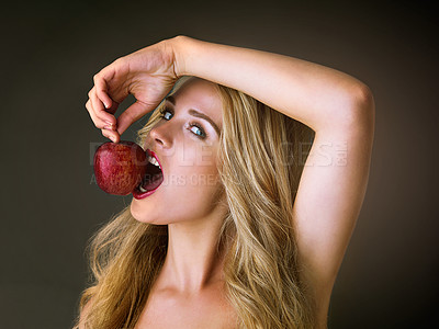 Buy stock photo Girl, portrait and sexy with apple in studio for eating or beauty, organic cosmetics and natural dermatology for alluring feel. Seductive, woman and forbidden fruit on dark background for nutrition.