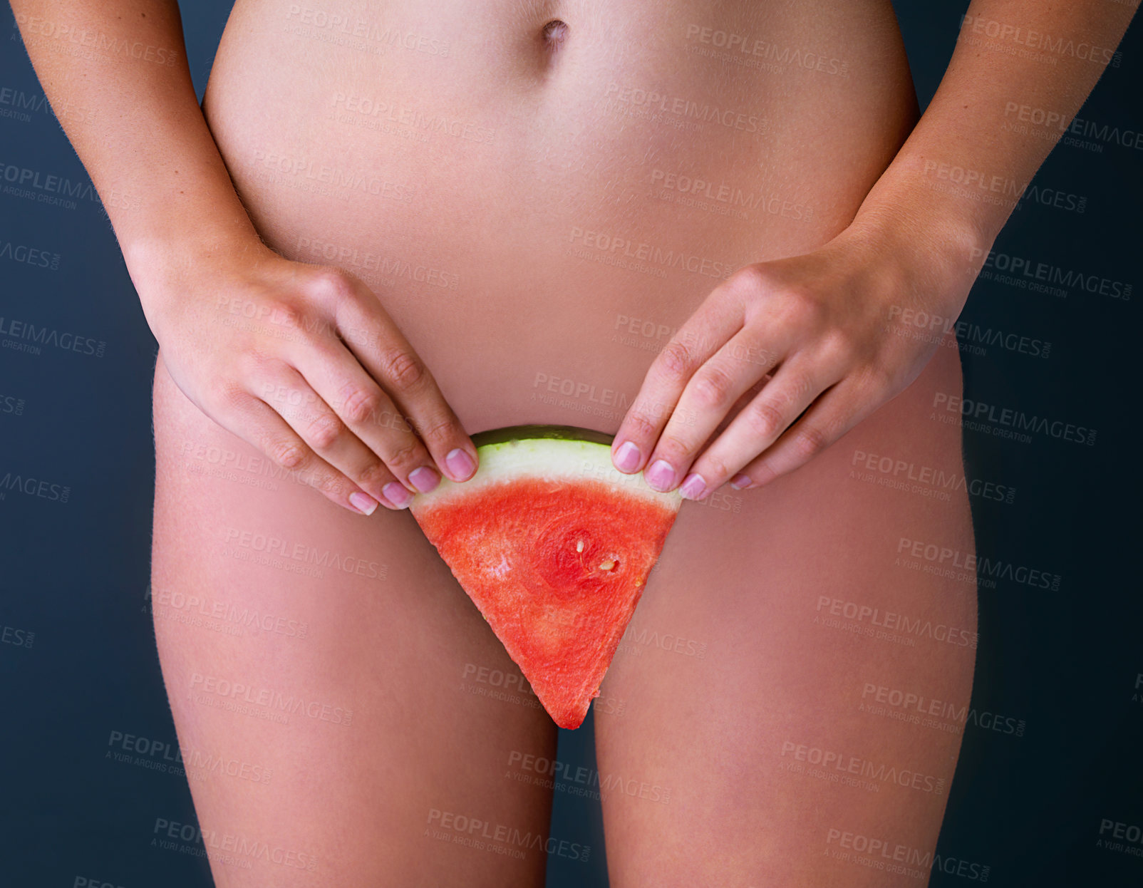 Buy stock photo Cropped studio shot of a woman suggestively holding a slice of watermelon in front of her pelvic area