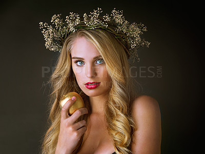 Buy stock photo Portrait, beauty and woman with gold apple isolated on black studio background. Face, food and girl eating forbidden fruit for magic, temptation or sin of model in flower wreath with makeup cosmetics