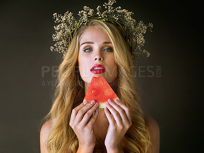 Buy stock photo Makeup, woman and beauty portrait with watermelon for forbidden fruit, desire and temptation with cosmetics. Aphrodite, girl goddess and flower crown with lipstick and eating on studio background