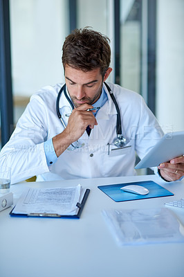 Buy stock photo Cropped shot of a young doctor working in his office
