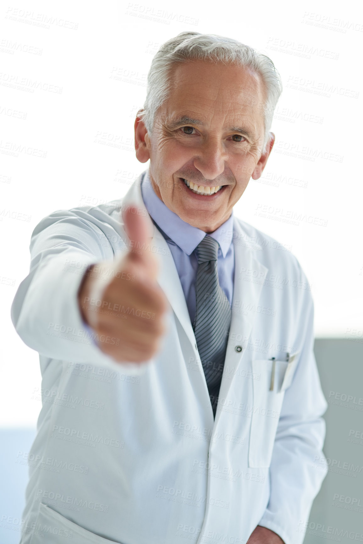 Buy stock photo Portrait of a mature doctor showing thumbs up in a hospital