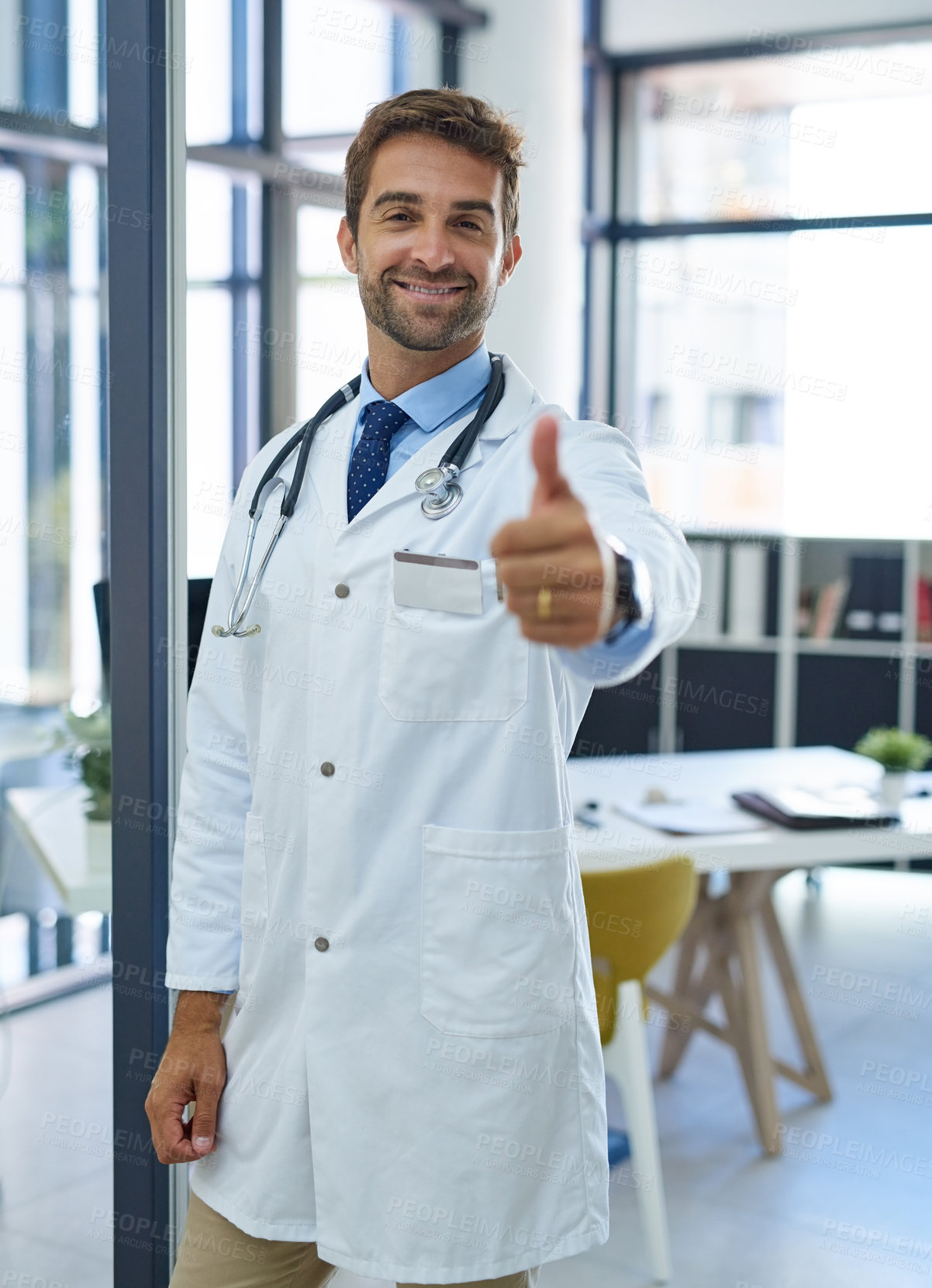 Buy stock photo Portrait of a young doctor showing thumbs up in his office