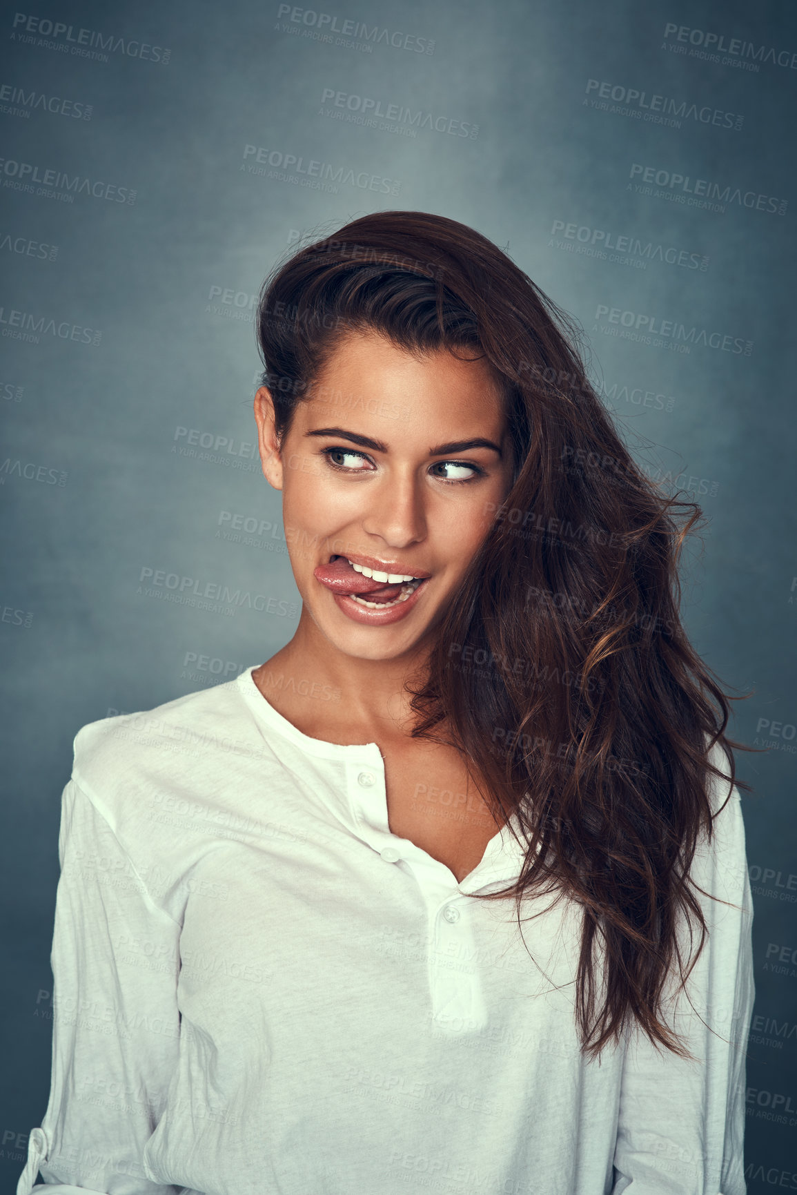 Buy stock photo Funny face, tongue and comedy of woman, silly and confident by backdrop, hair and casual fashion. Happy female person, beauty and emoji or goofy, care and joke or pose, comedy and gray background