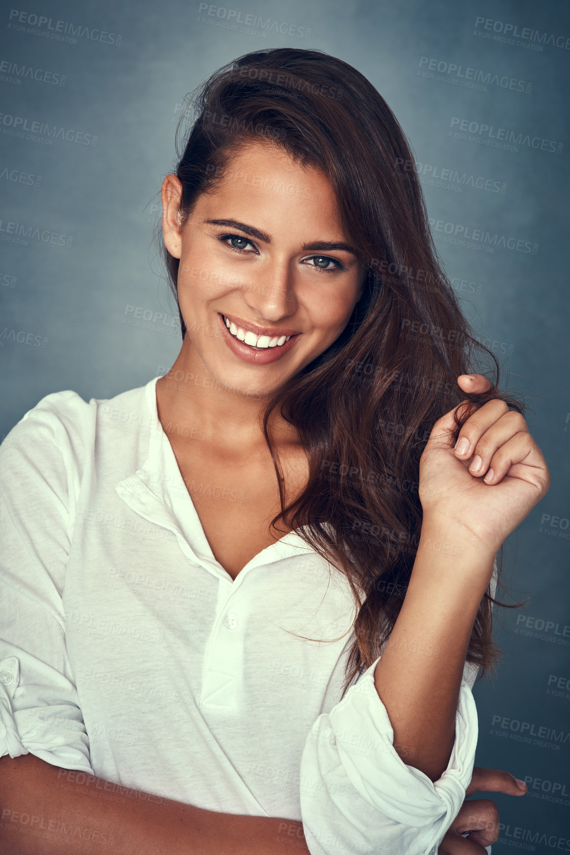 Buy stock photo Portrait of a beautiful young woman smiling against a gray background in studio