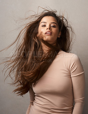 Buy stock photo Portrait of a beautiful young woman posing with the wind in her hair in studio