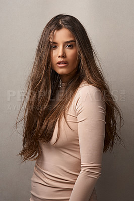 Buy stock photo Portrait of a beautiful young woman posing with the wind in her hair in studio