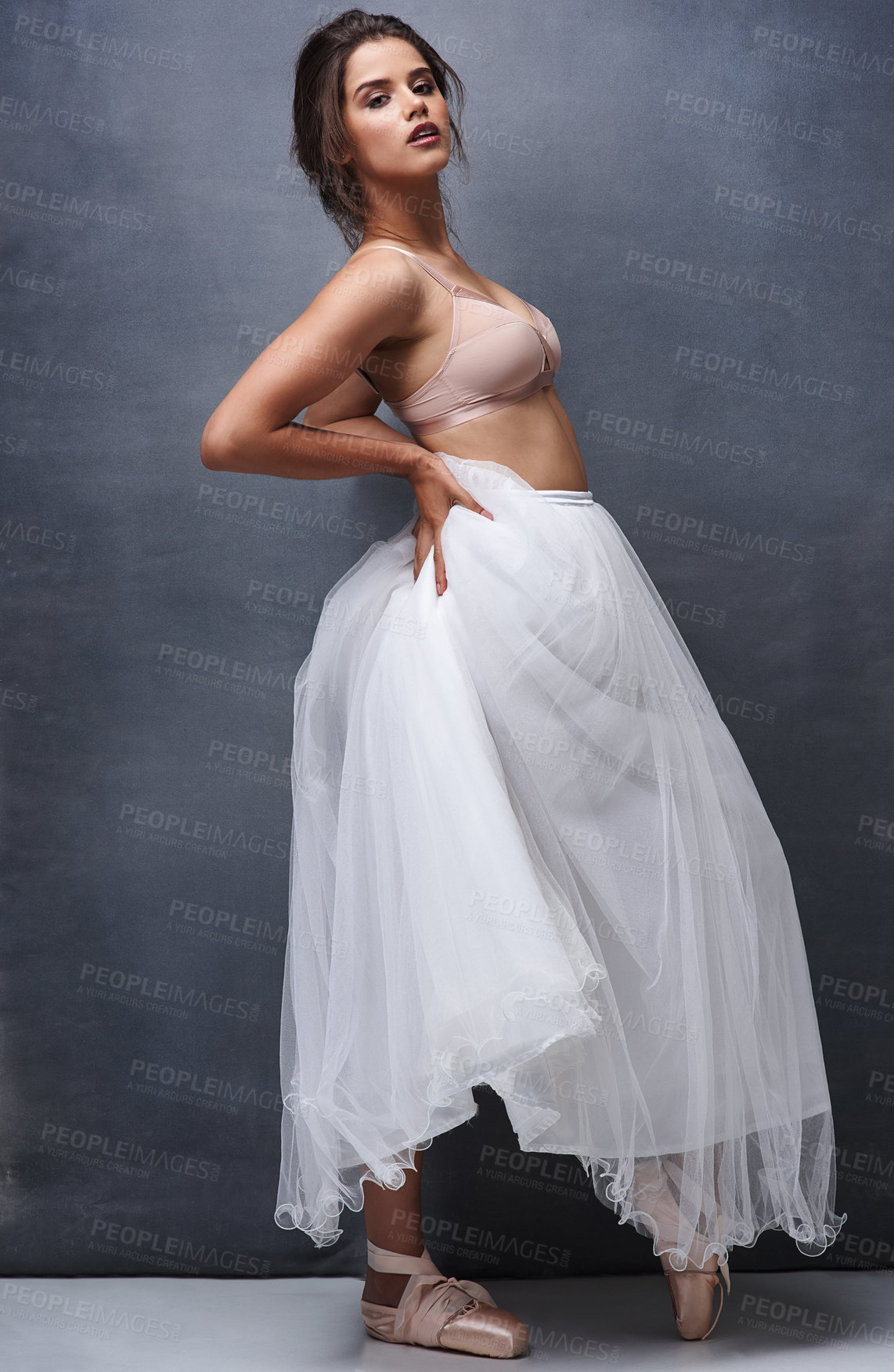 Buy stock photo Portrait of a beautiful young woman posing in studio while wearing a bra and ballet skirt