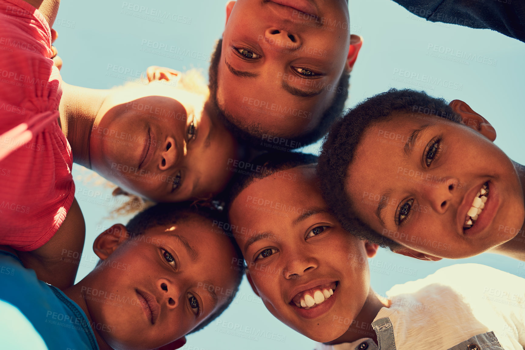 Buy stock photo Portrait of a group of children standing arm in arm in a huddle outside