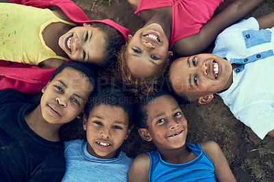 Buy stock photo High angle portrait of children lying on the grass together outside