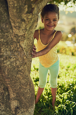 Buy stock photo Girl, portrait and outdoor by tree for playing, childhood and nature game for growth development. Female person, freedom and happy in environment for fun, weekend and adventure on holiday travel