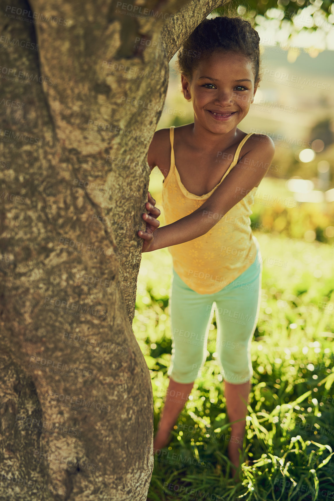 Buy stock photo Girl, portrait and outdoor by tree for playing, childhood and nature game for growth development. Female person, freedom and happy in environment for fun, weekend and adventure on holiday travel