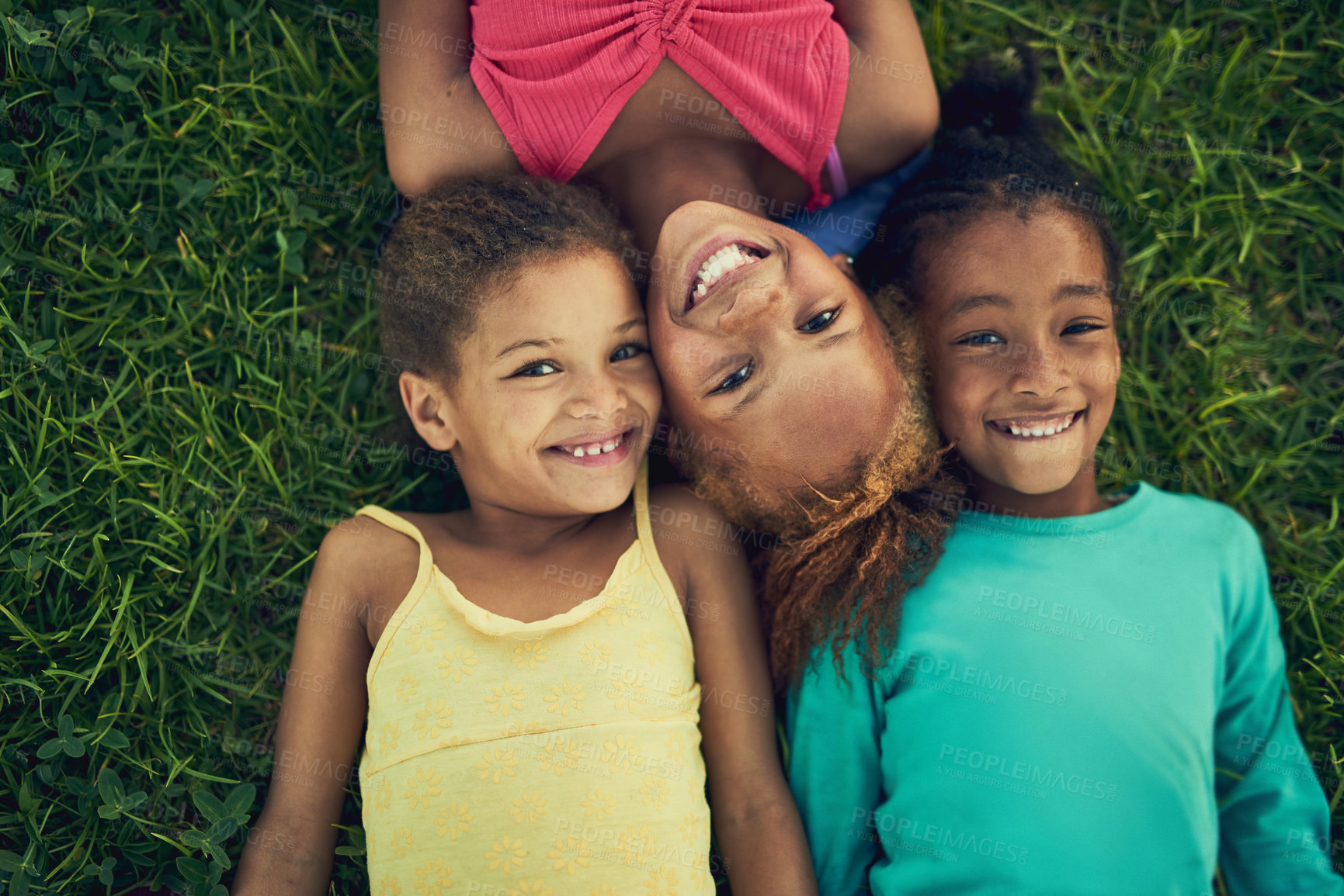 Buy stock photo High angle portrait of three little girls lying on the grass together outside