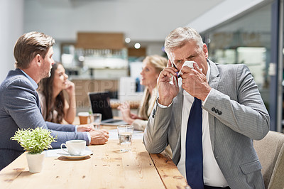 Buy stock photo Cropped shot of a businessman blowing his nose while talking on a cellphone in an office