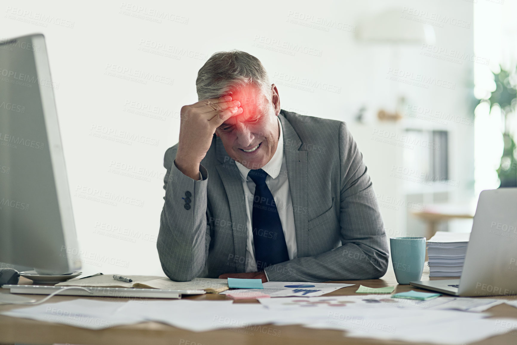 Buy stock photo Shot of a businessman with a headache holding his head while sitting at his desk