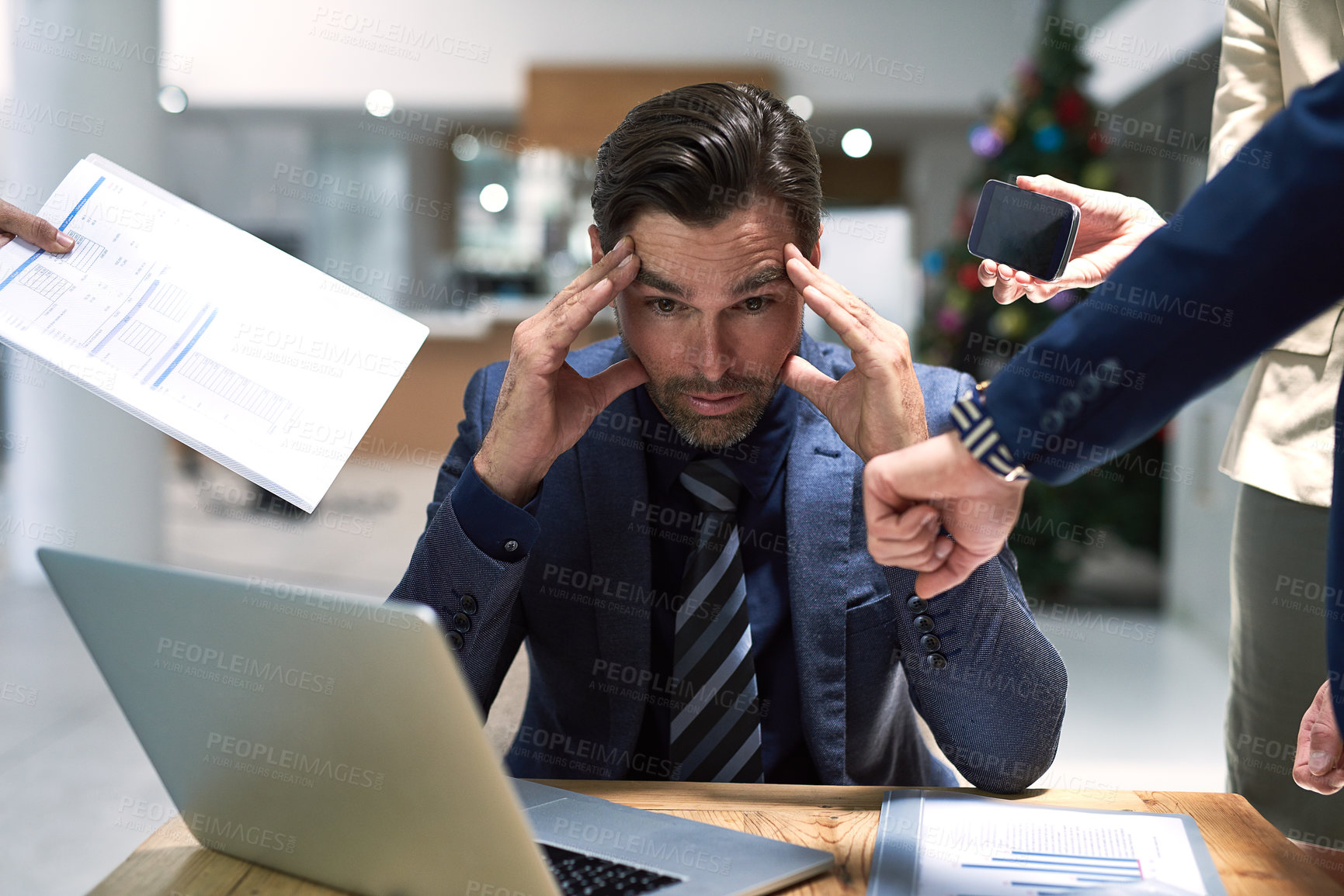 Buy stock photo Shot of a stressed out businessman sitting at his office desk overwhelmed by work demands