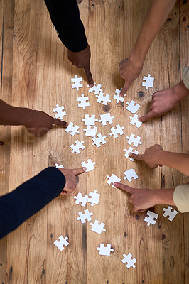 Buy stock photo High angle shot of a group of unidentifiable businesspeople building a puzzle together in the office