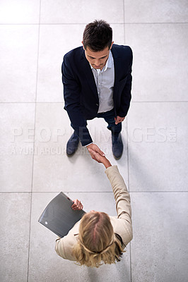 Buy stock photo High angle shot of two professional businesspeople shaking hands in the office