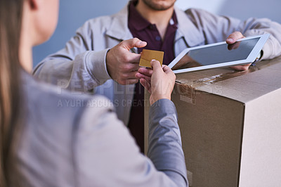 Buy stock photo Cropped shot of a courier accepting a credit card payment for a delivery