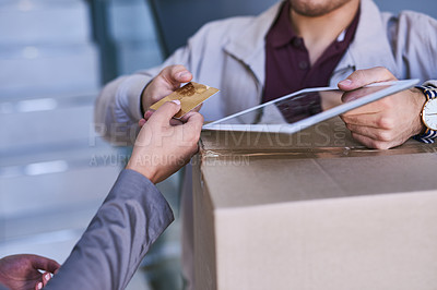 Buy stock photo Cropped shot of a courier accepting a credit card payment for a delivery