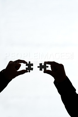 Buy stock photo Cropped shot of two people holding puzzle pieces together against a white background